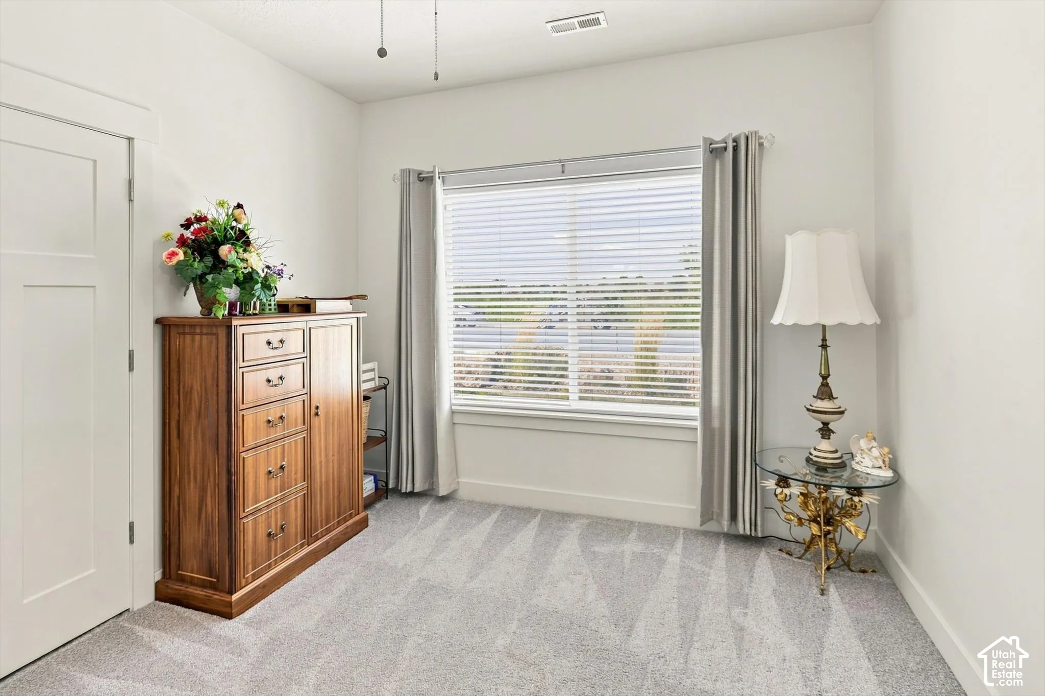 Window with horizontal blinds, light gray wall-to-wall carpeting, white interior door, and ceiling fan