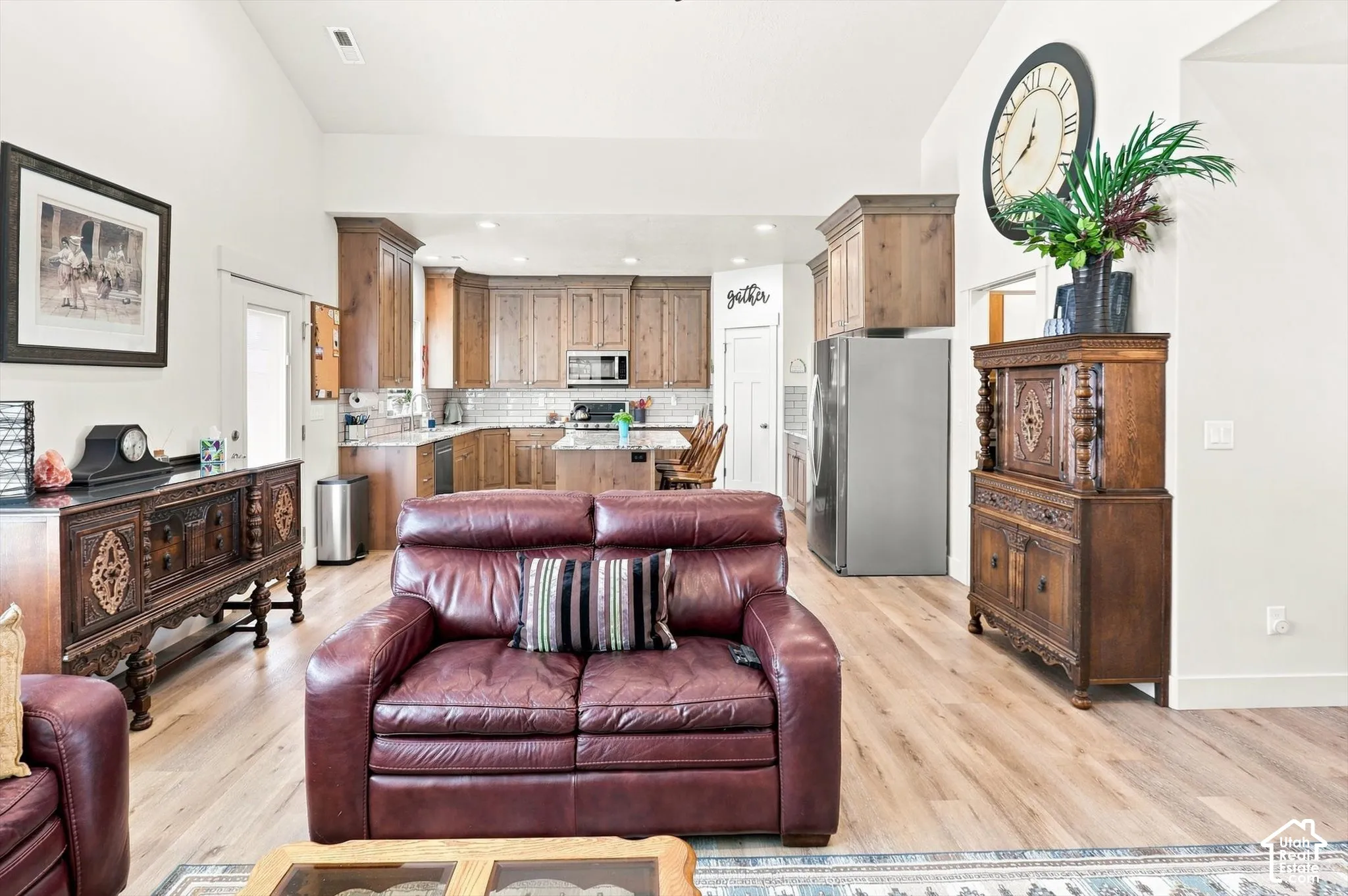 Expansive living area with vaulted ceilings, light wood-finish flooring, and recessed lighting
