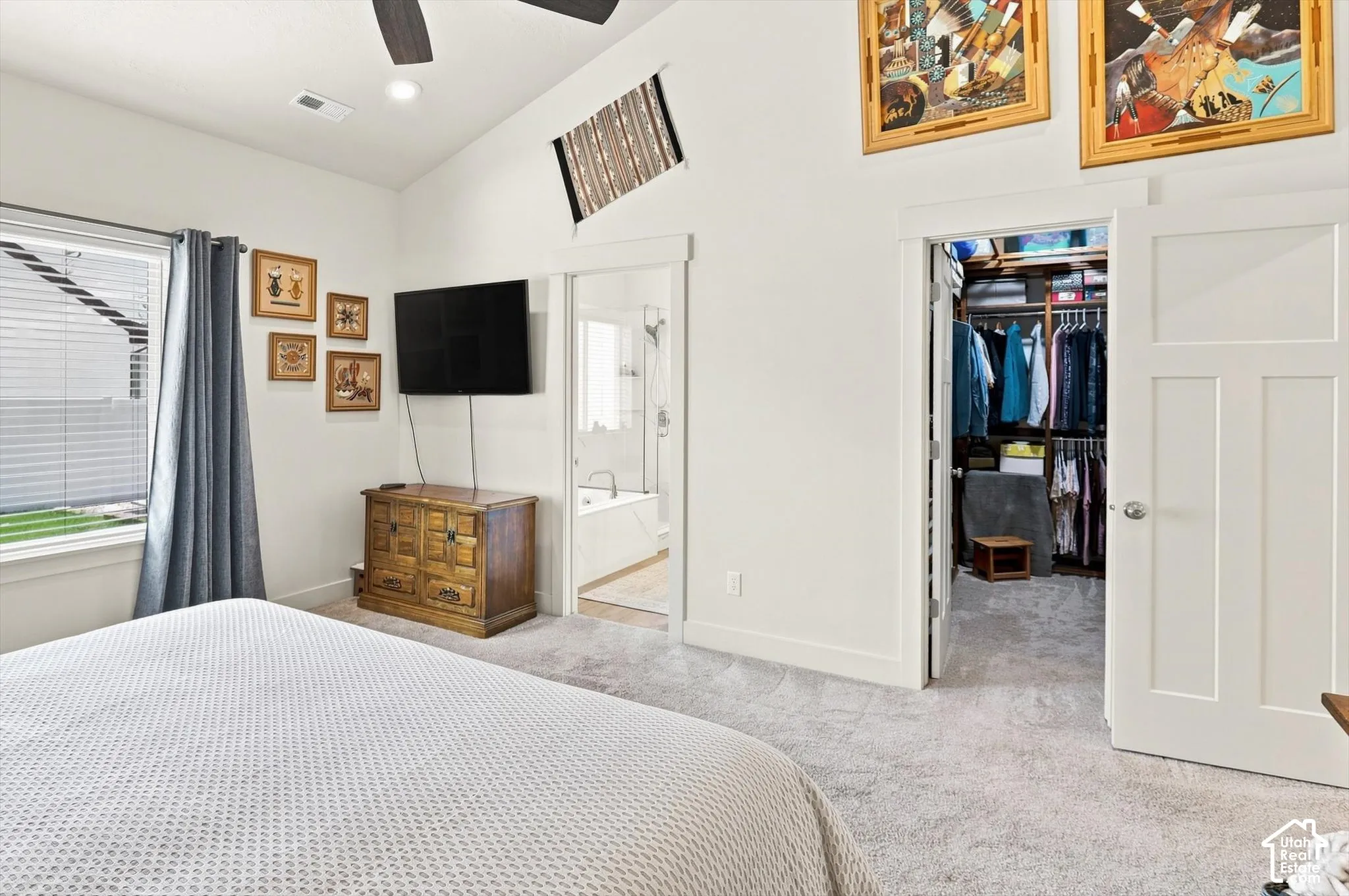 Vaulted ceilings, a ceiling fan, plush carpeting, a walk-in closet, and a soaking tub