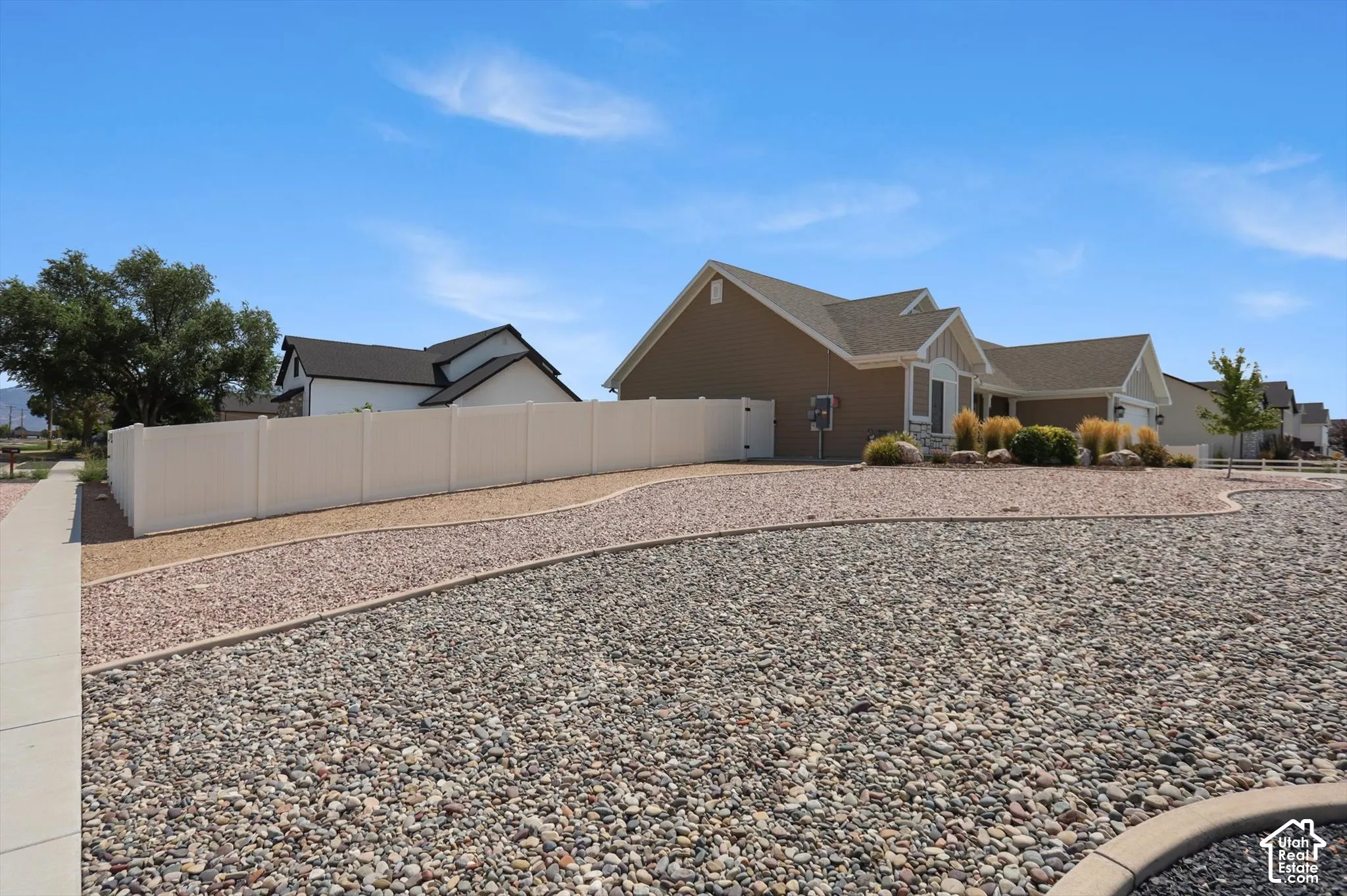 Tan siding exterior with a dark shingle roof