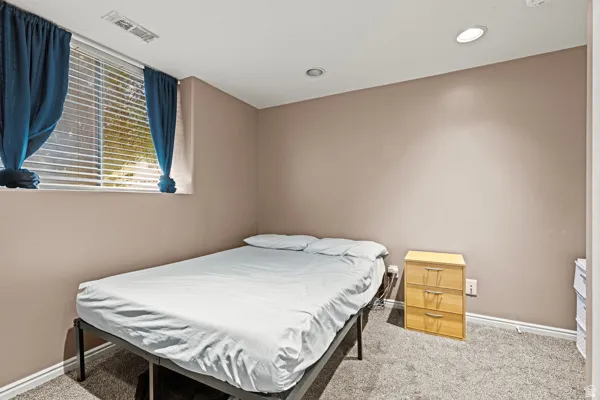 Recessed ceiling lighting, carpeted flooring, window with blinds, and light-toned wall finishes