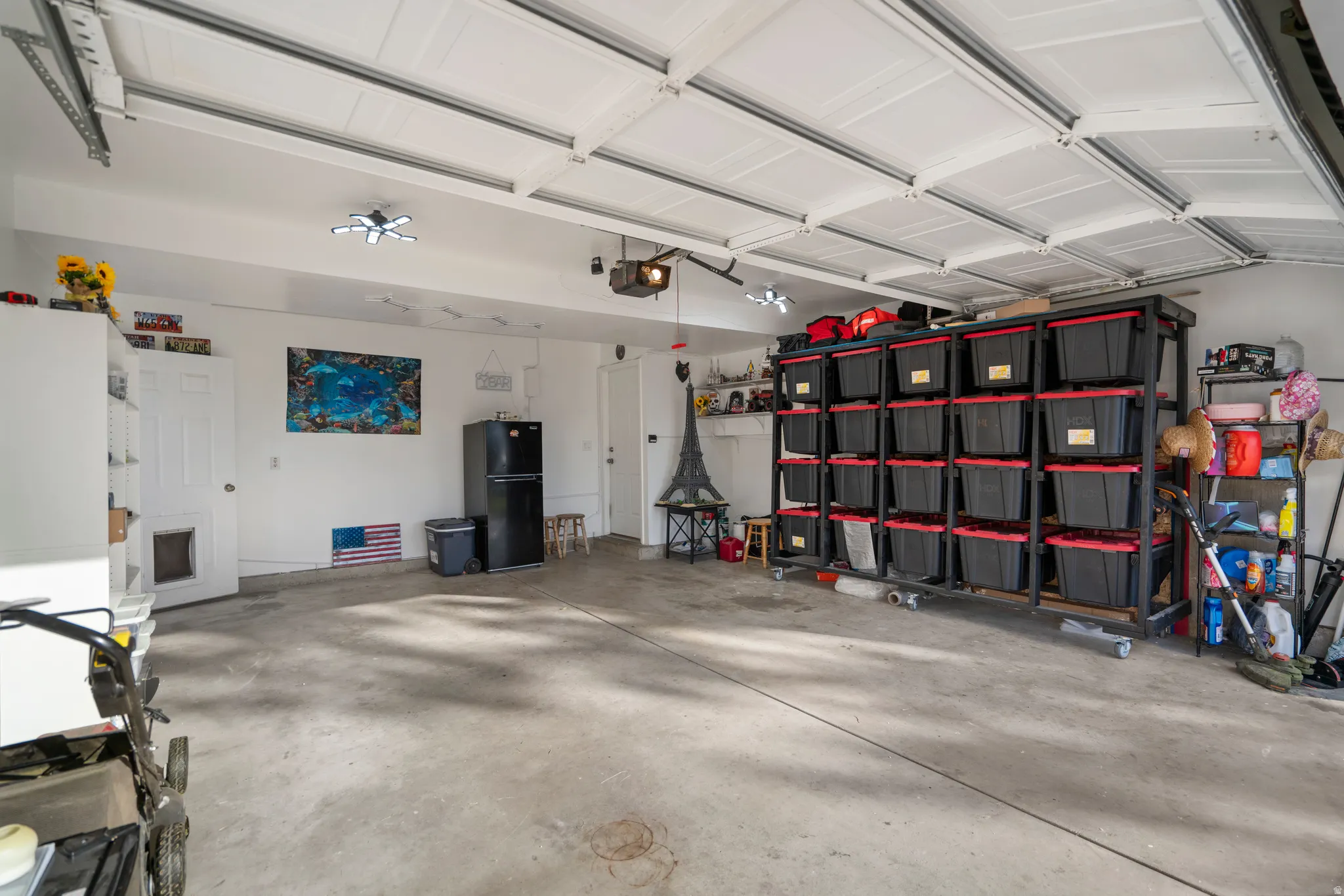 Spacious garage featuring a concrete floor, built-in overhead lighting, and a paneled garage door