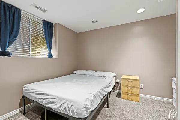 Recessed ceiling lighting, carpeted flooring, window with blinds, and light-toned wall finishes