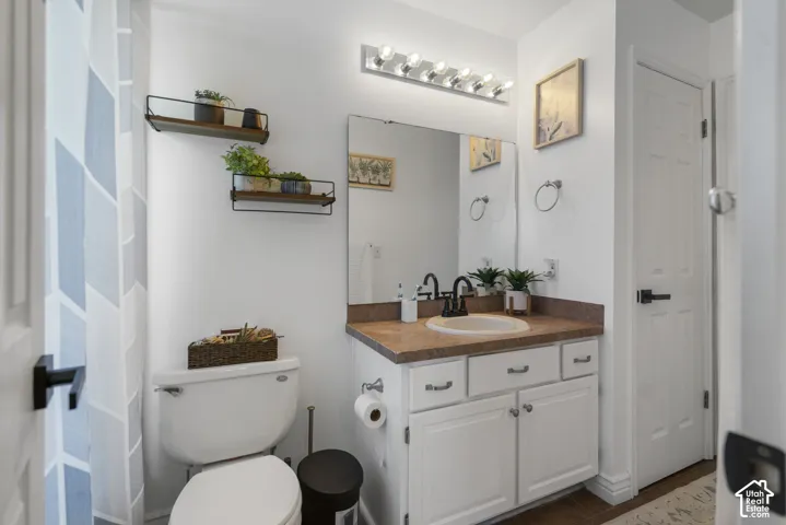 Vanity with an integrated sink and matte black faucet, wall-mounted mirror, and white cabinetry