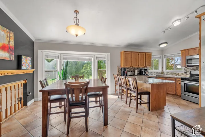 Bay window feature, tile flooring, wood-finish cabinetry, stone-finish countertops, and stainless steel appliances