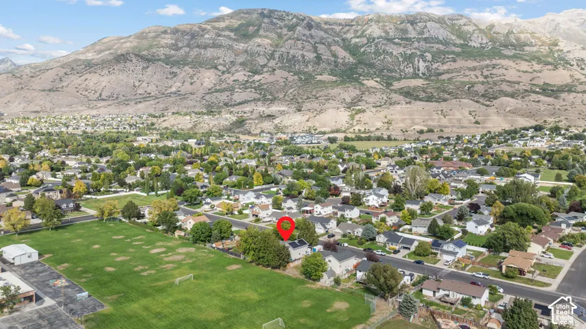 Expansive residential neighborhood with mature trees, mountain backdrop, and adjacent green space