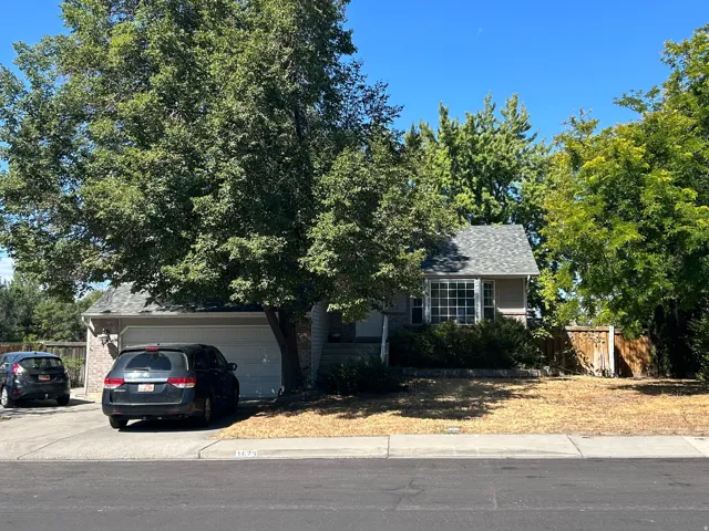 Single-family residence with an attached garage, bay window, and a shingled roof