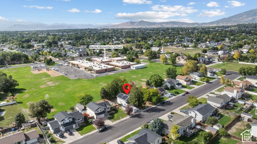 Residential neighborhood with mature trees, established landscaping, and mountain backdrop