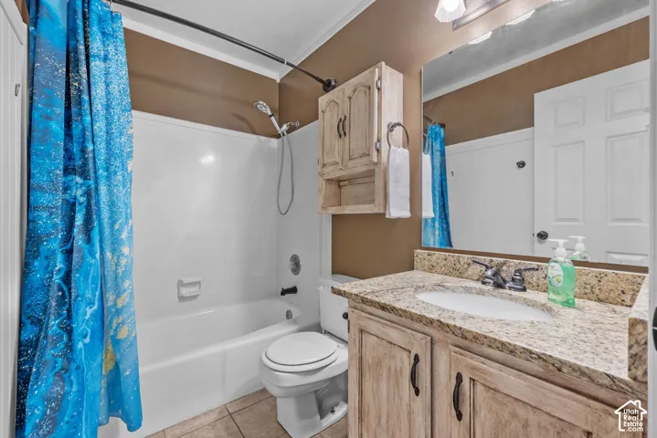 Bathroom featuring a vanity with an integrated sink, a built-in medicine cabinet, a full-sized mirror, a shower-tub combination, and tiled flooring