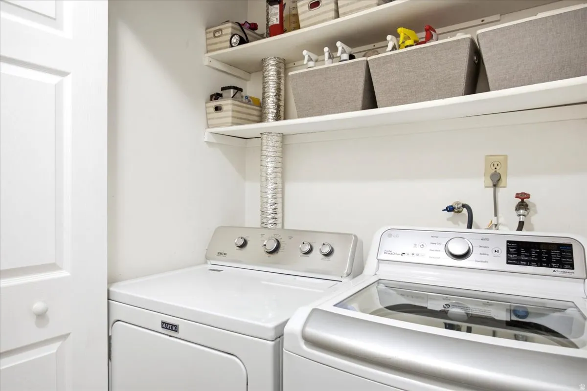 Dedicated laundry area featuring white shelving and a paneled door