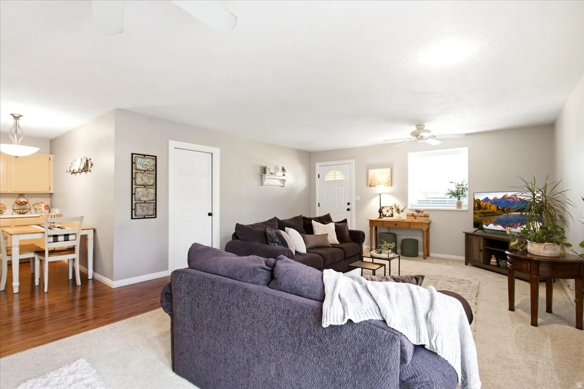 Open-concept living area featuring hardwood flooring, neutral wall finishes, and abundant natural light from multiple windows