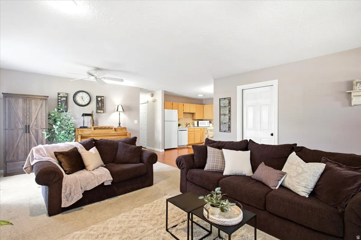 Open-concept living area with neutral wall tones and a ceiling fan