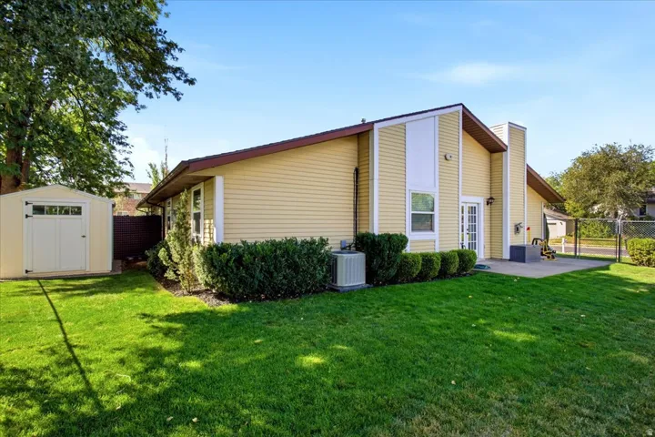 Yellow siding exterior with white trim accents and a brown roof
