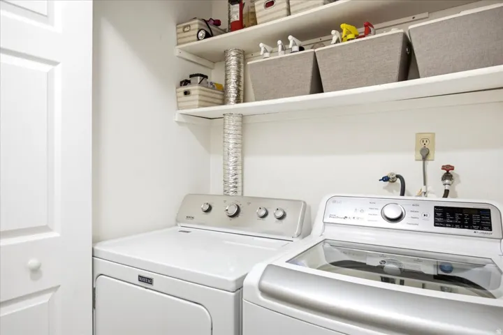 Dedicated laundry area featuring white shelving and a paneled door