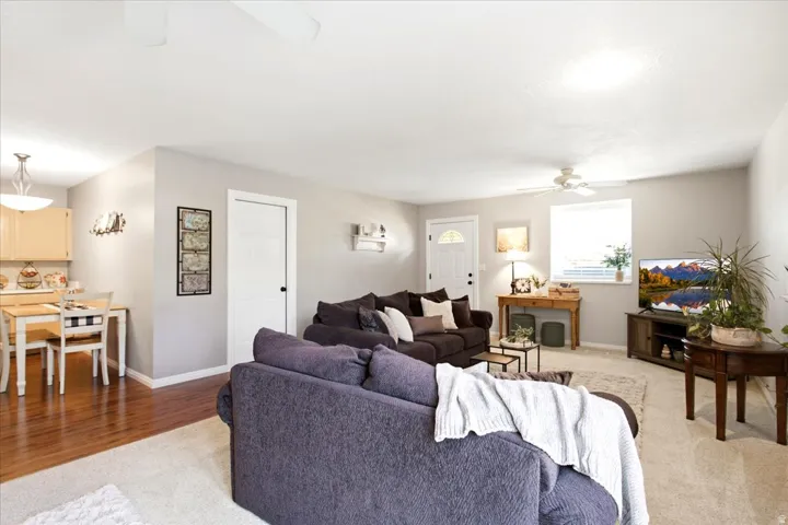 Open-concept living area featuring hardwood flooring, neutral wall finishes, and abundant natural light from multiple windows