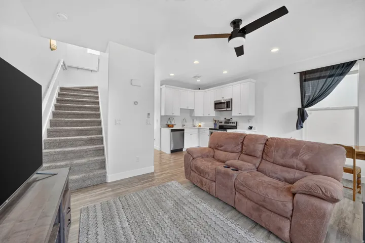 Open-concept living area featuring wood-finish flooring, recessed lighting, and a ceiling fan