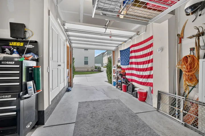 Attached garage featuring a concrete floor, storage space and overhead storage racks