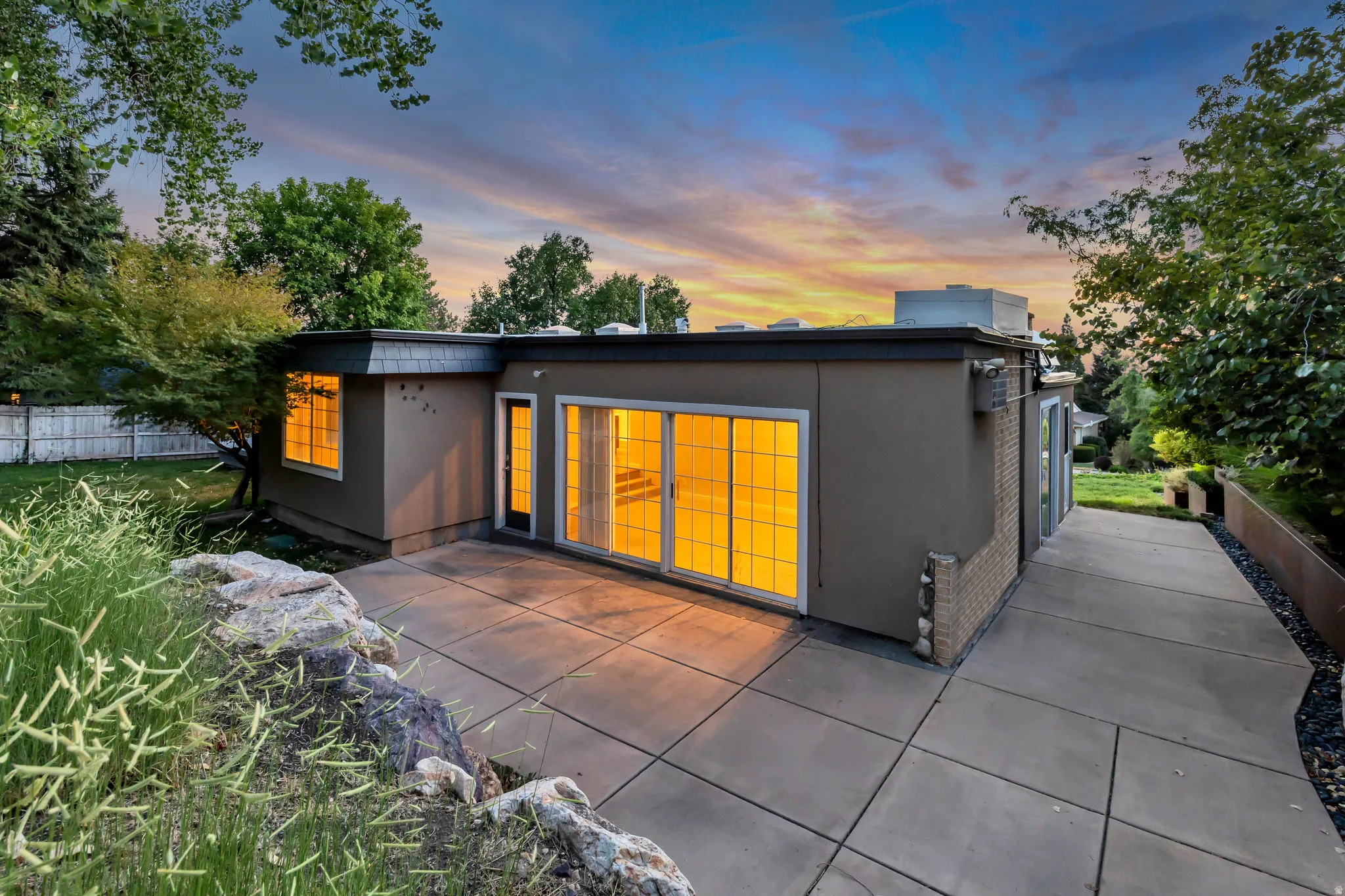 Exterior with smooth stucco finish, sliding glass doors, and a concrete patio