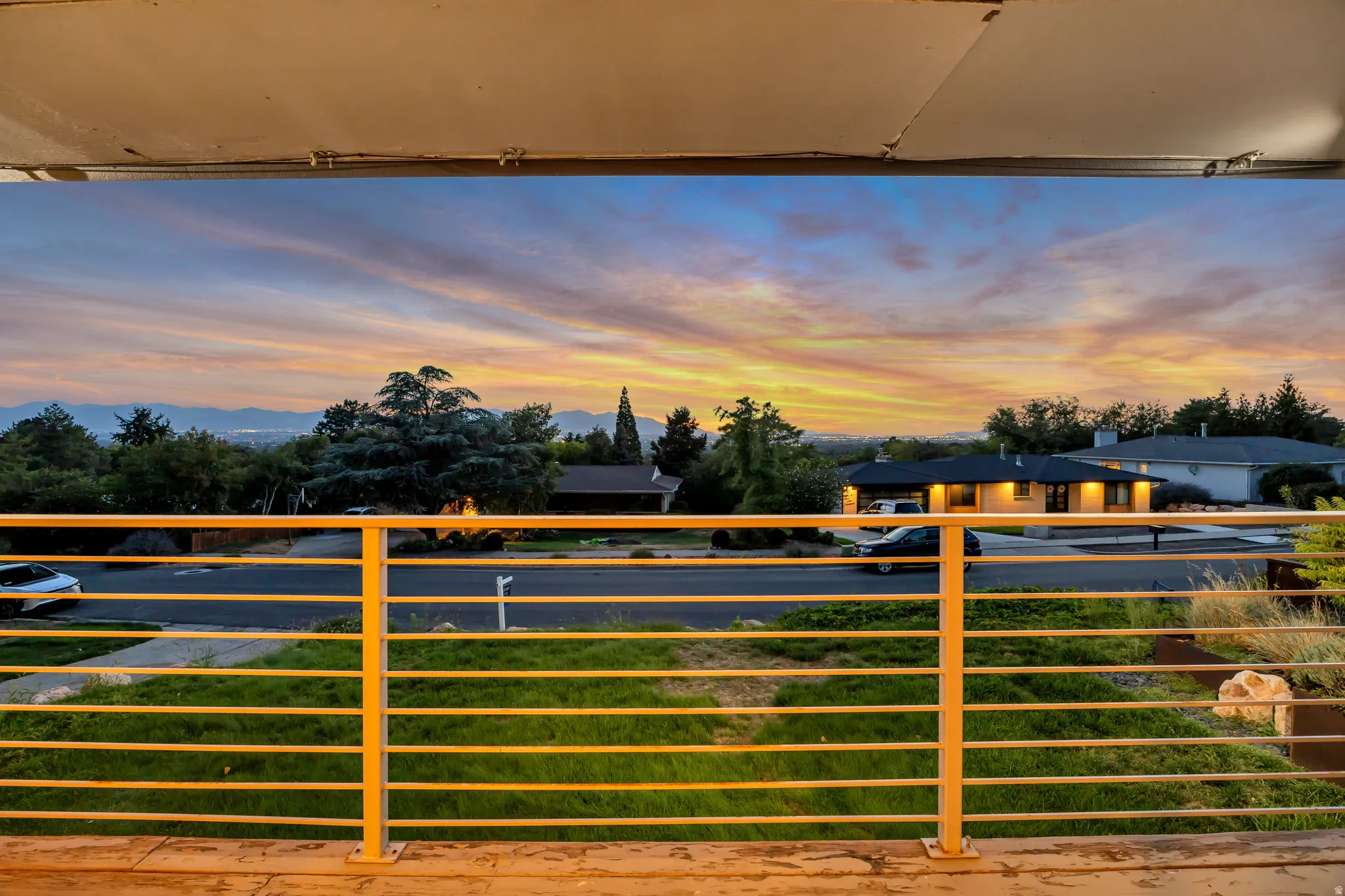 Balcony with horizontal metal railings and distant mountain range