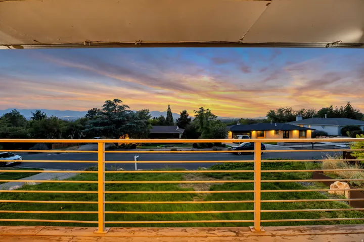 Balcony with horizontal metal railings and distant mountain range