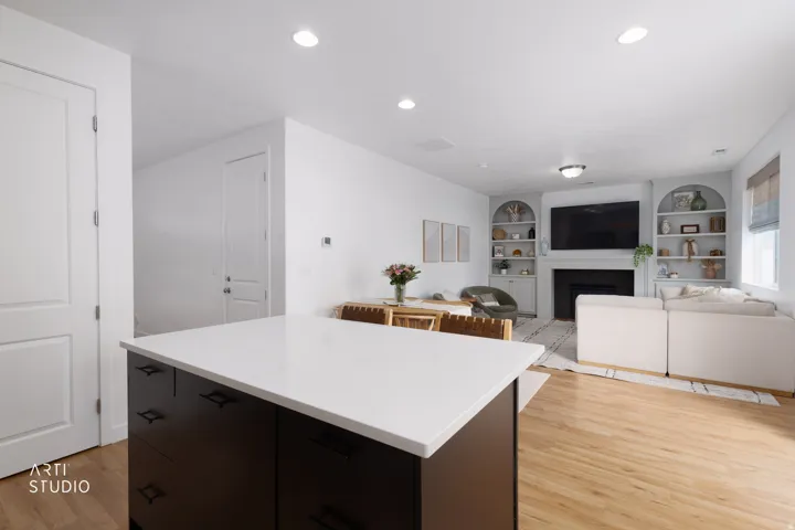 Kitchen island with white quartz countertops and dark cabinetry