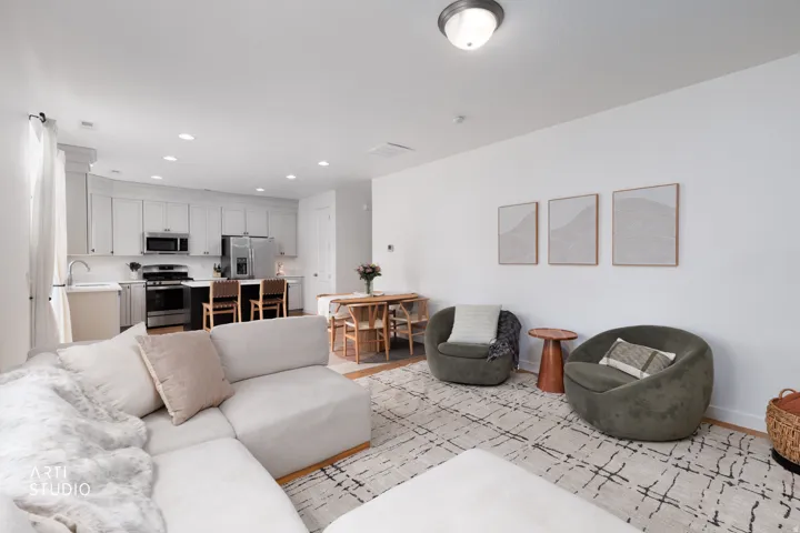 Open-concept living space featuring wood-finish flooring, white walls, and recessed lighting