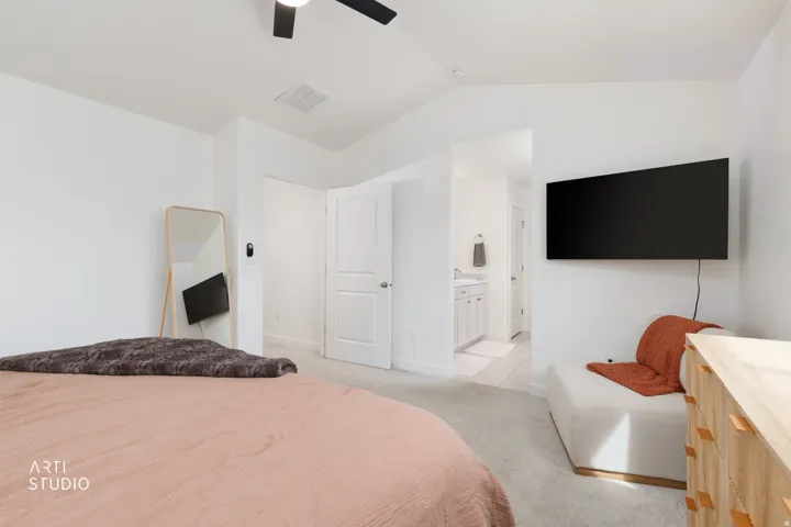 Vaulted ceiling, ceiling fan, wall-mounted television, and carpeted flooring
