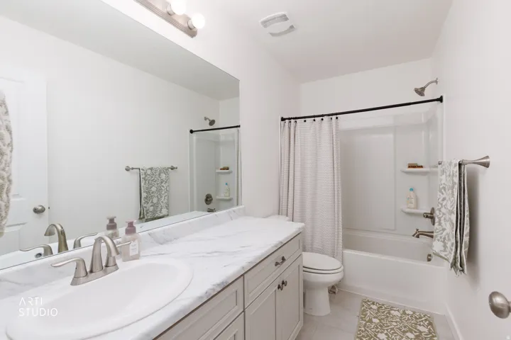 Vanity with integrated sink, marble-finish countertop, and brushed nickel faucet