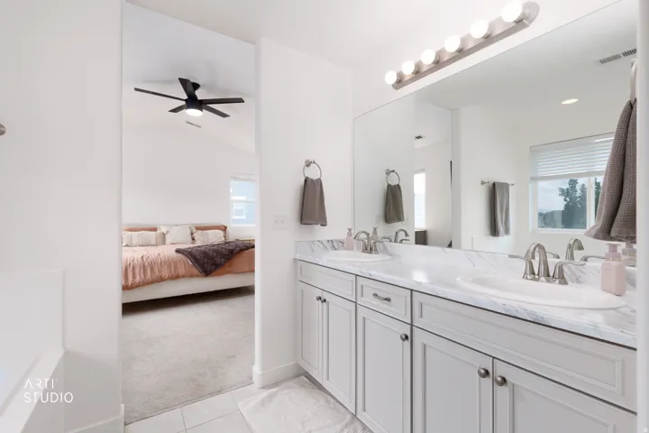 Double vanity with undermount sinks, Marble-finish countertop, and brushed nickel fixtures