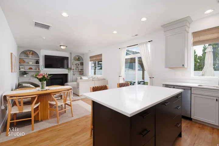 Kitchen island with white Quartz countertop, recessed lighting, wood-finish flooring, built-in shelving, and sliding glass door