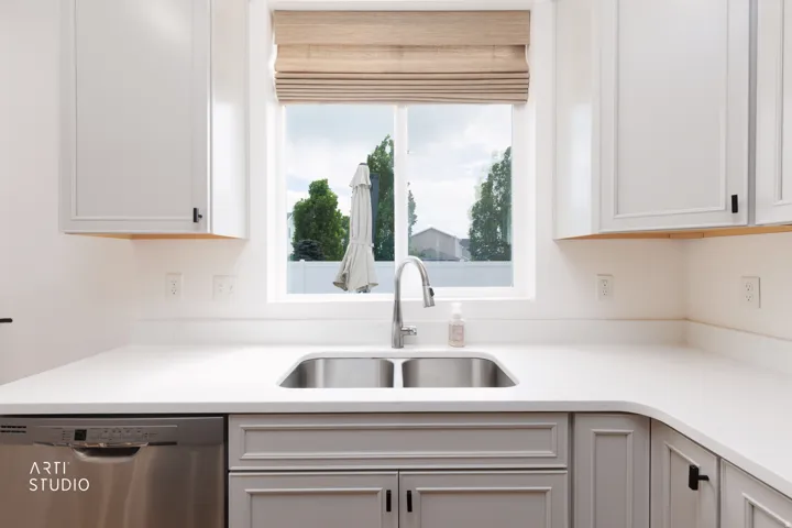 Stainless steel double-basin sink with a gooseneck faucet