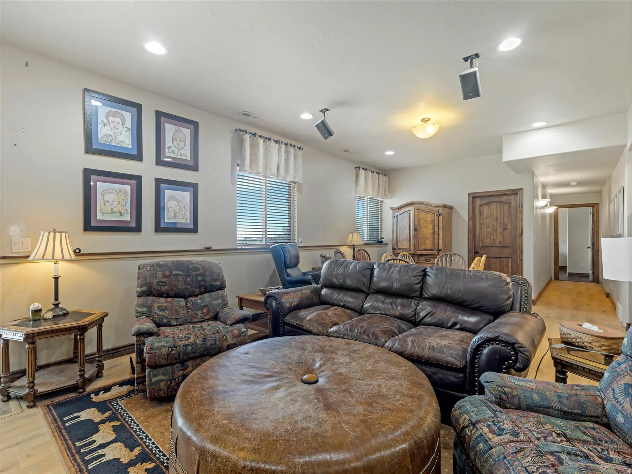 Spacious living room with recessed ceiling lighting, ceiling fan, and large windows with plantation shutters