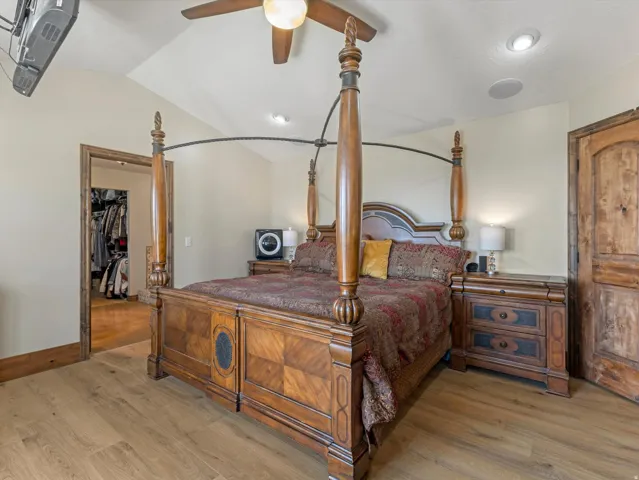 Master Bedroom - Vaulted ceiling with recessed lighting and a ceiling fan, wood-finish flooring, and a solid wood door