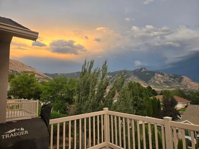 Balcony featuring a beige railing and mountain backdrop