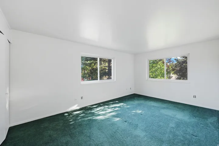 White painted walls with green carpeting