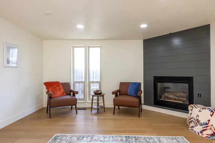 Corner fireplace with a dark gray shiplap-style surround and hearth