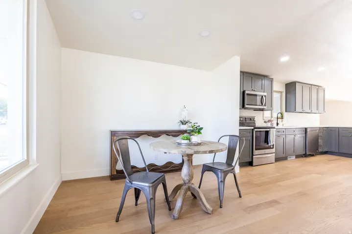 Kitchen featuring grey cabinetry, stainless steel appliances, white countertops, and wood-finish flooring