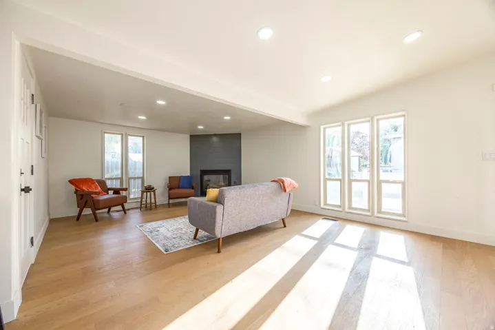 Spacious living area featuring light wood-finish flooring and recessed lighting