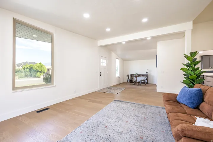 Expansive living space featuring wood-finish flooring, recessed lighting, and a large window