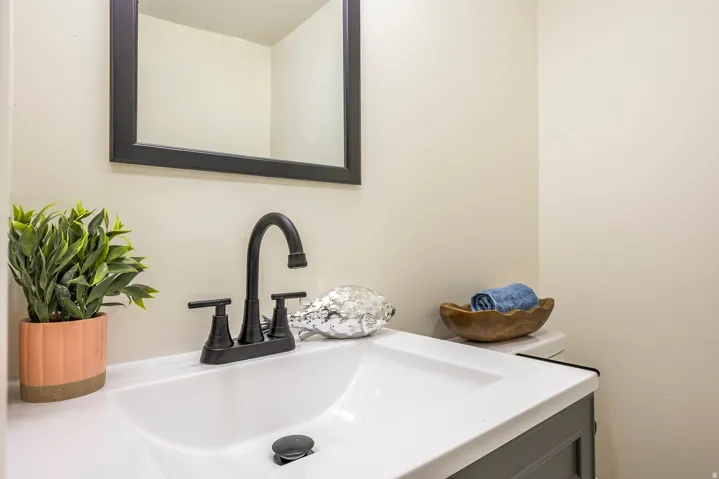 Integrated vanity sink with a matte black faucet, framed mirror, and light-toned walls
