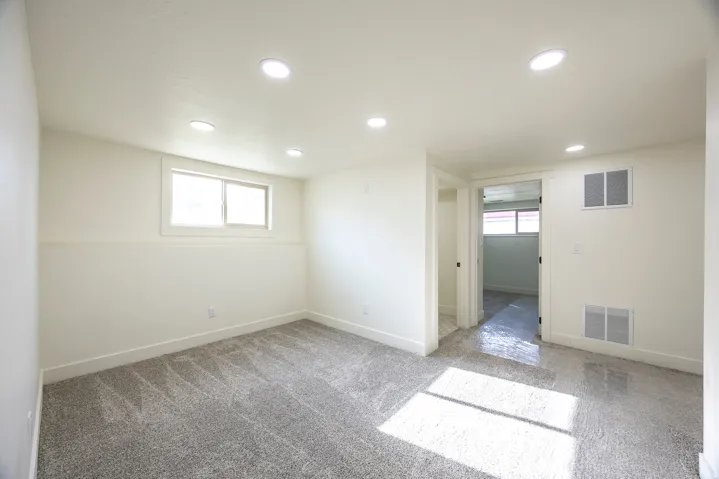 Neutral-toned walls, recessed lighting, and soft gray carpeting