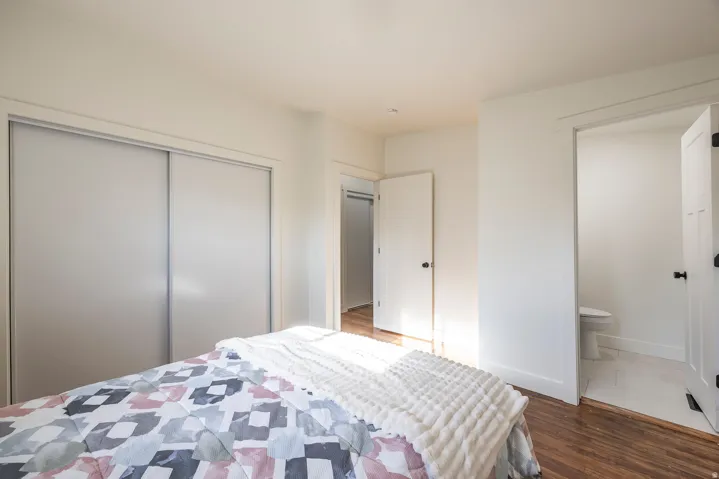 Wood-finish flooring, white walls, and a sliding door closet