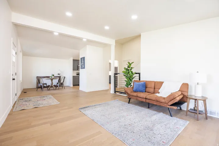 Expansive living space featuring wood-finish flooring, recessed lighting, and white wall finishes