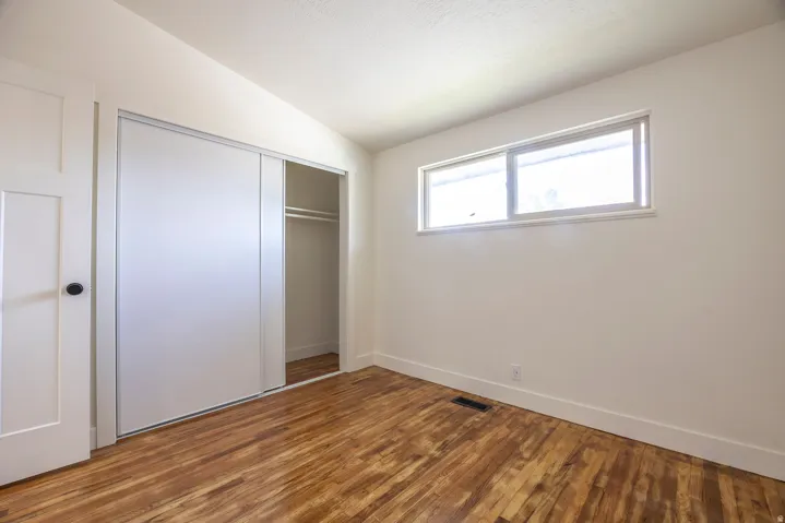 Wood-finish flooring, white walls, and a window with natural light