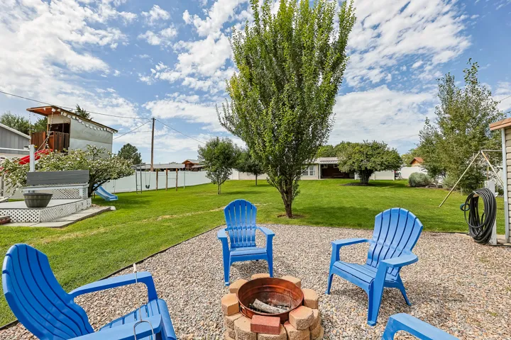 A large lawn, mature trees, and a built-in recreational feature provide multiple options for outdoor enjoyment and activities.