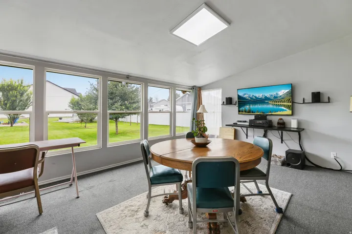 Large windows fill this dining space with natural light and views of the landscaped yard.