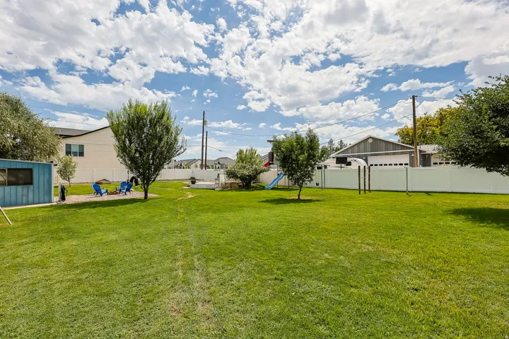 Mature trees, established landscaping, and a broad grassy area create a versatile outdoor setting with room for a variety of activities.