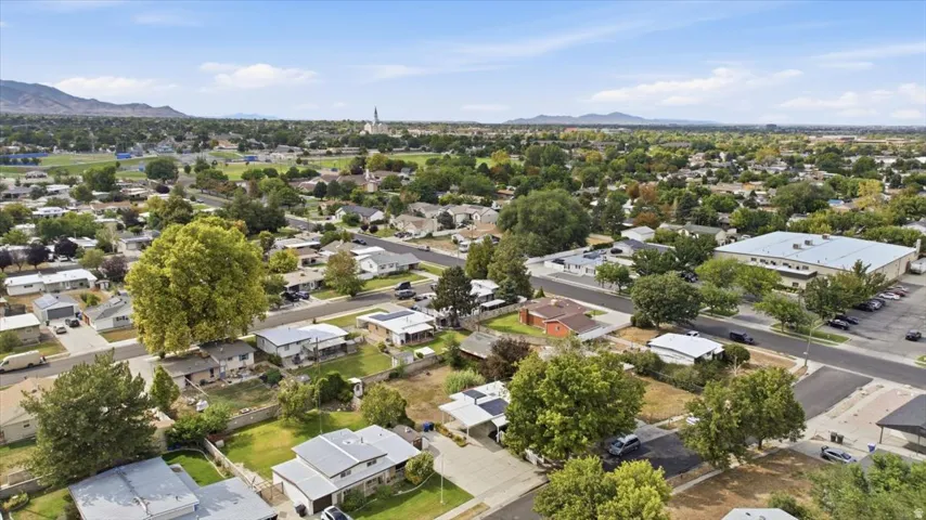Spacious residential area featuring a variety of properties, established trees, paved streets, and distant mountain ranges