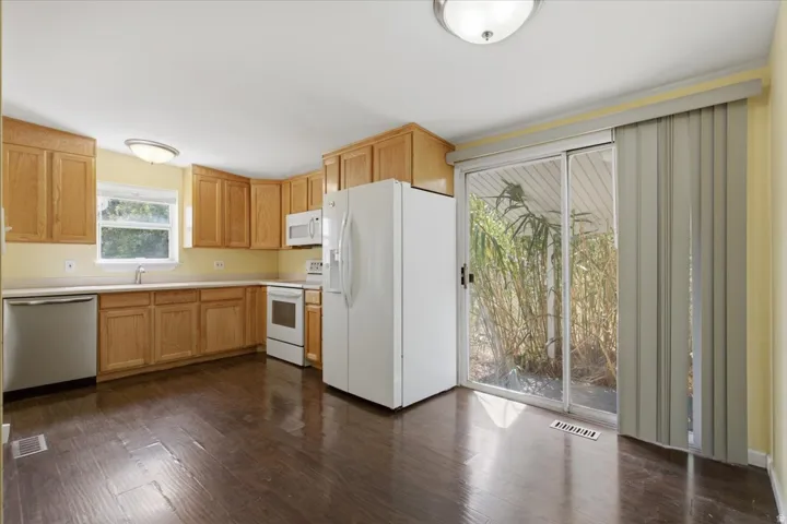 Kitchen featuring wood-finish flooring, oak cabinetry, and a sliding glass door