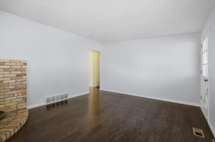 Wood-finish flooring, light-colored walls, and a brick fireplace